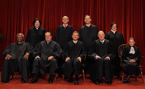 U.S. Supreme Court members pose for photographs.